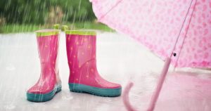 Pink children's rain boots and umbrella sitting on the side walk | Gunther Kia 