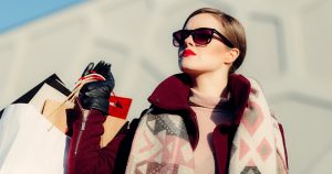 A woman in sunglasses and red lipstick with shopping bags | Gunther Kia