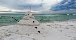 A snowman on the beach made out of sand | Gunther Kia