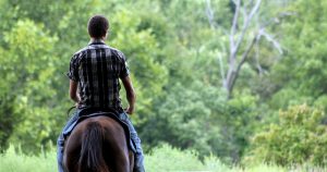 Teenage boy riding a horse in nature | Gunther Kia